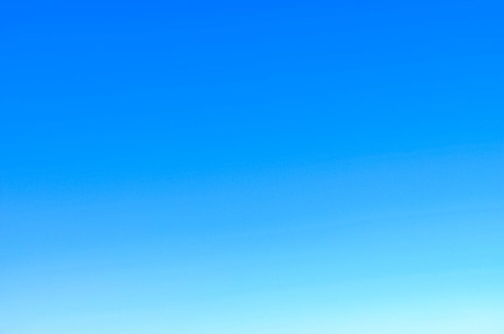 A serene view of a vibrant clear blue sky with a subtle gradient, perfect for backgrounds.